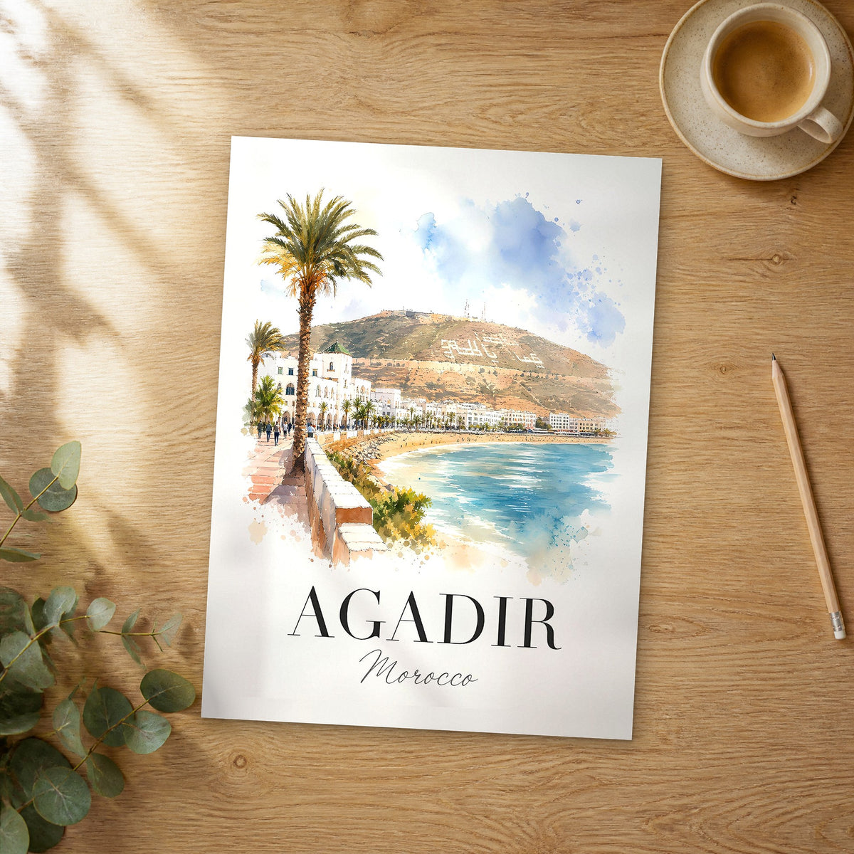 Unframed Agadir watercolor travel poster on a wooden table