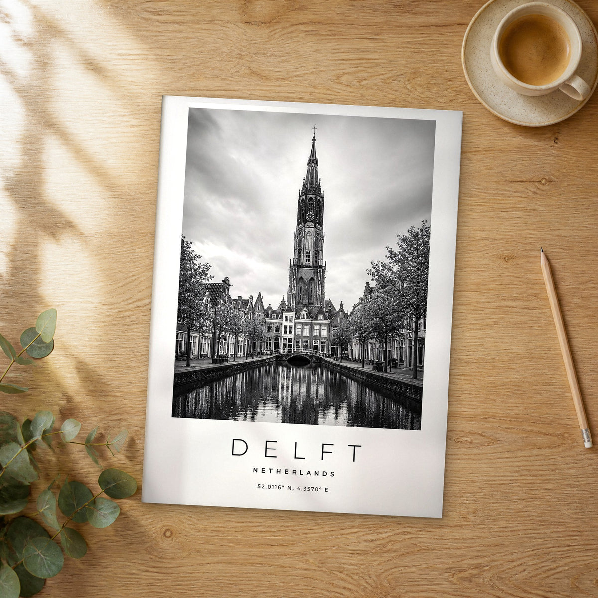 Unframed Delft black and white travel poster on a wooden table
