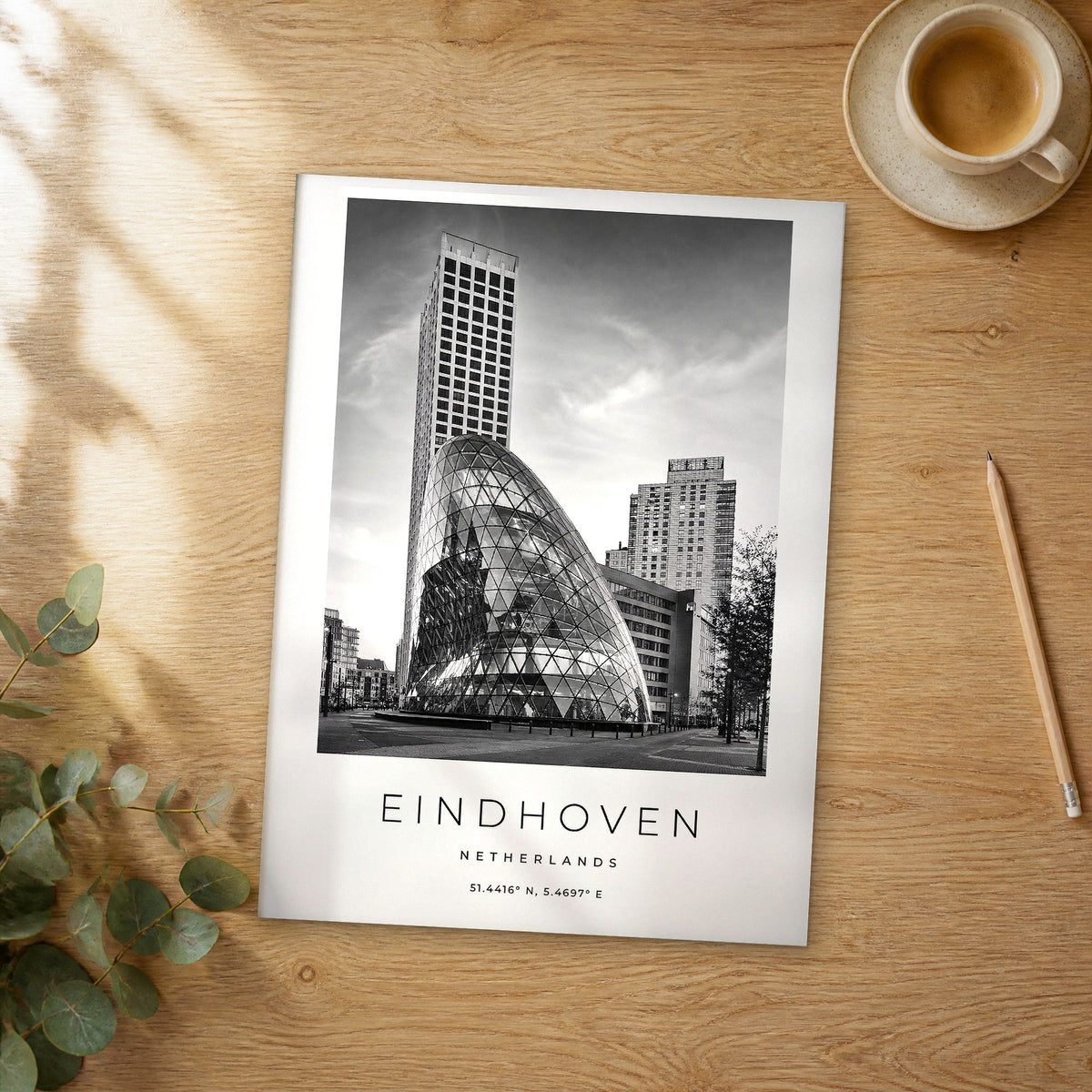 Unframed Eindhoven black and white travel poster on a wooden table