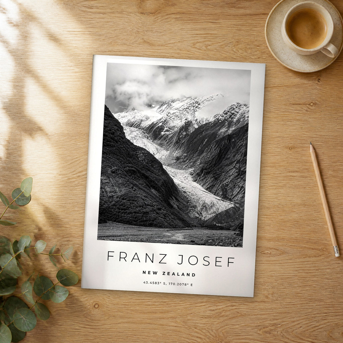 Unframed Franz Josef black and white travel poster on a wooden table