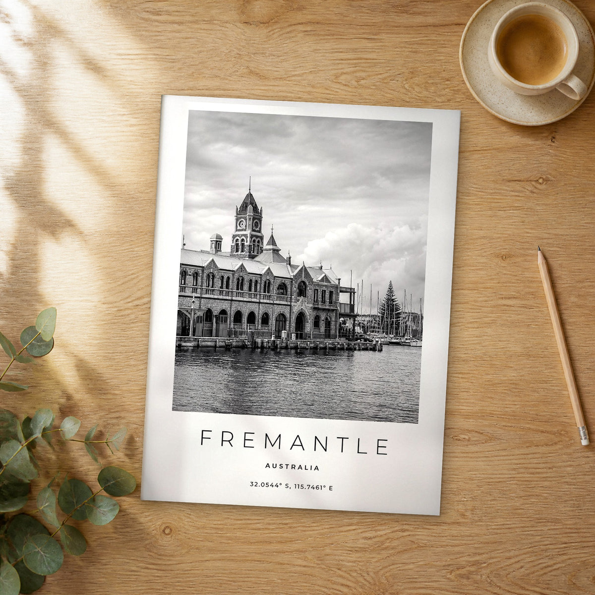 Unframed Fremantle black and white travel poster on a wooden table