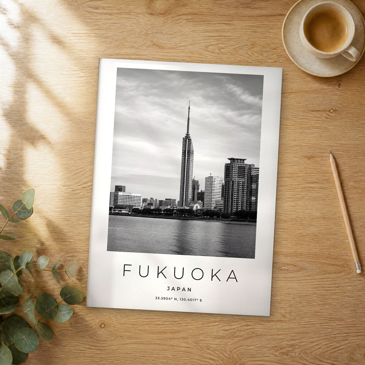 Unframed Fukuoka black and white travel poster on a wooden table