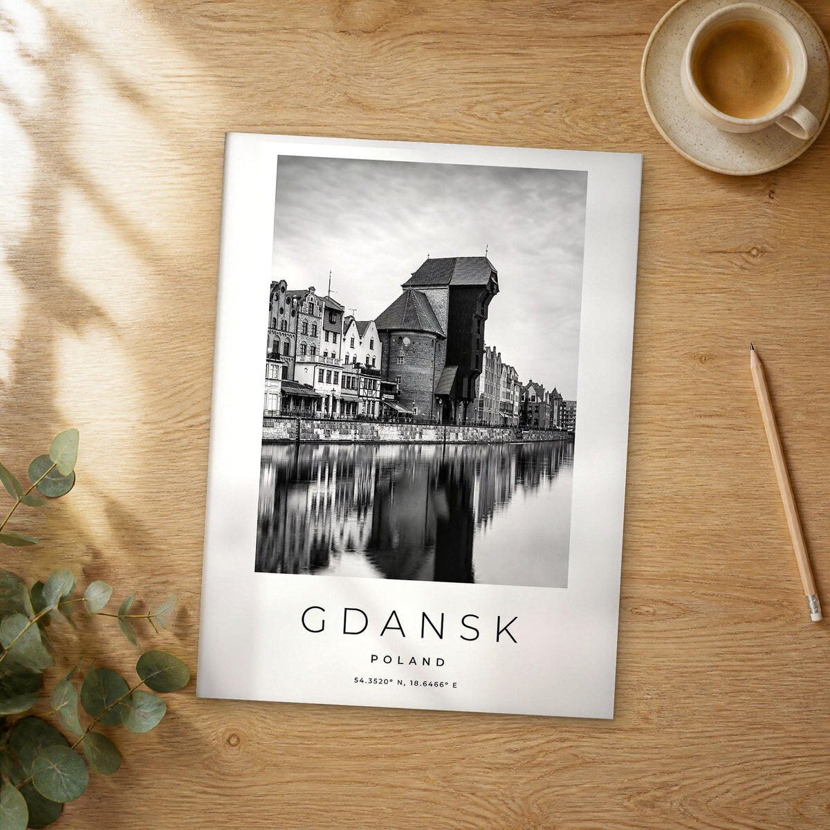 Unframed Gdansk black and white travel poster on a wooden table