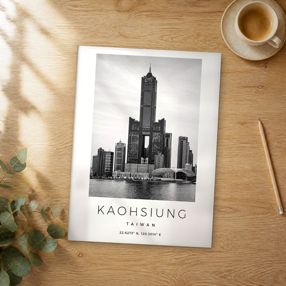 Unframed Kaohsiung black and white travel poster on a wooden table