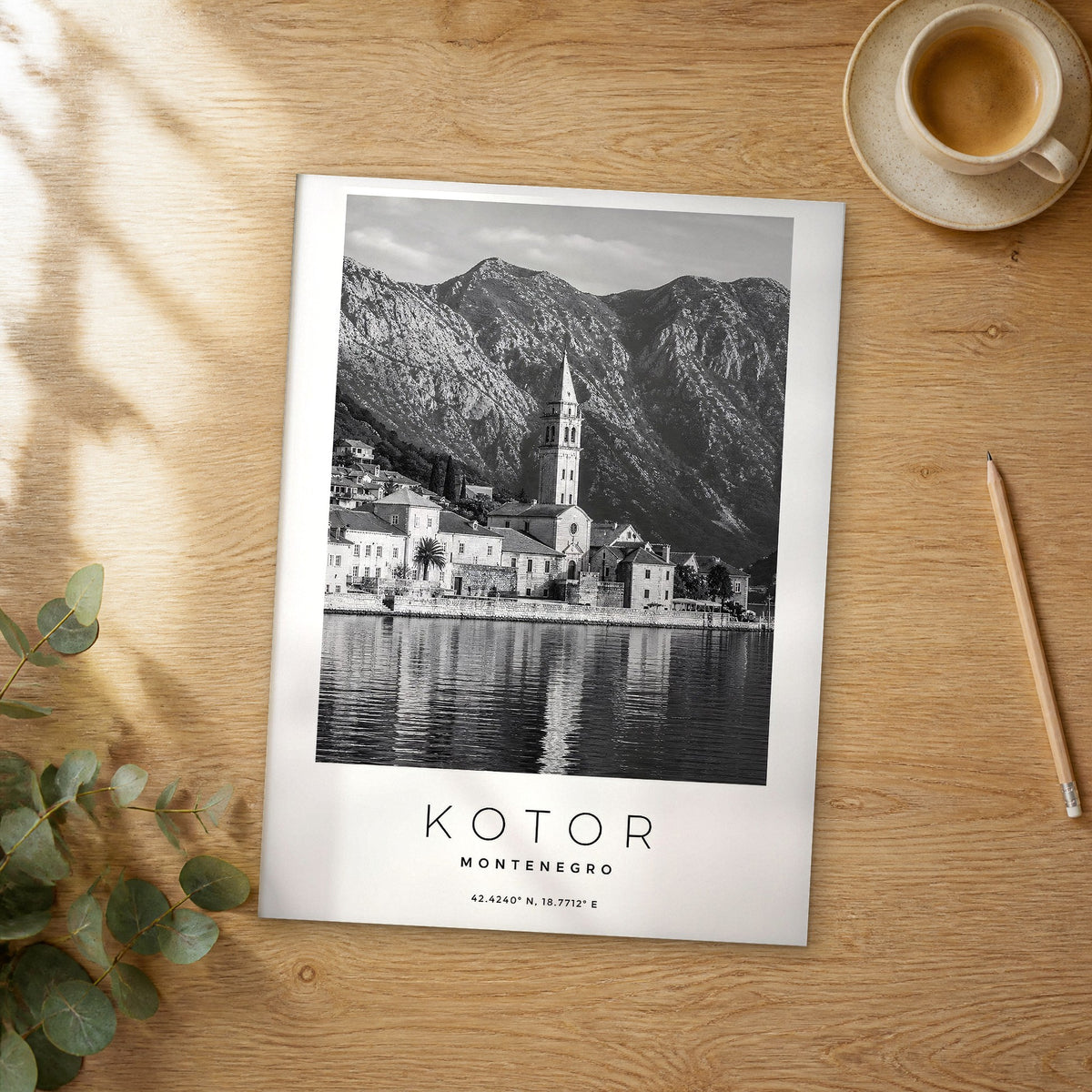 Unframed Kotor black and white travel poster on a wooden table