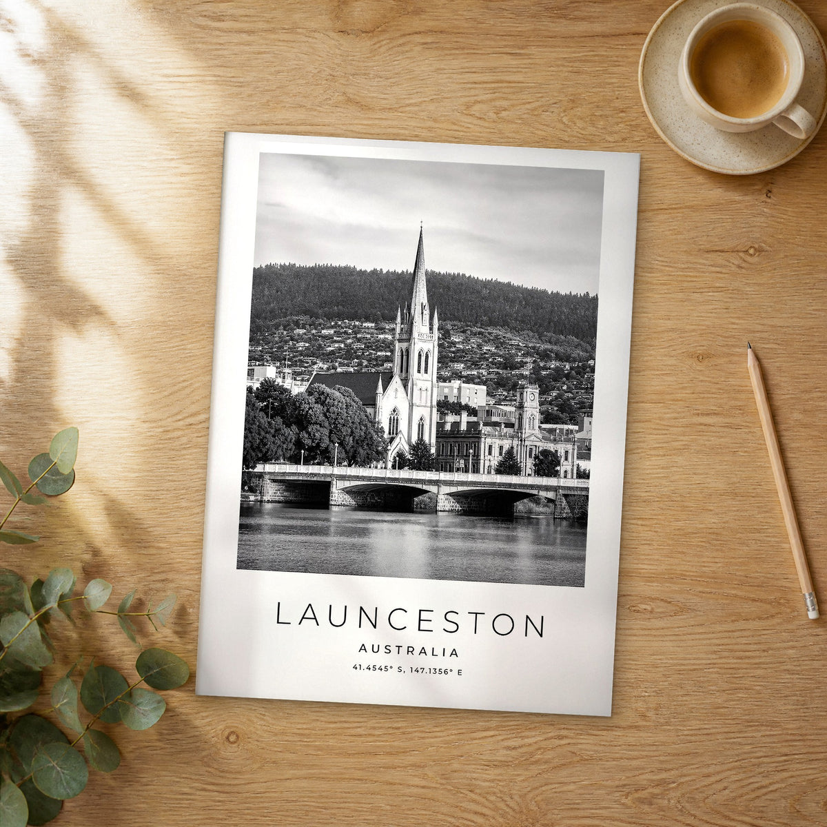 Unframed Launceston black and white travel poster on a wooden table