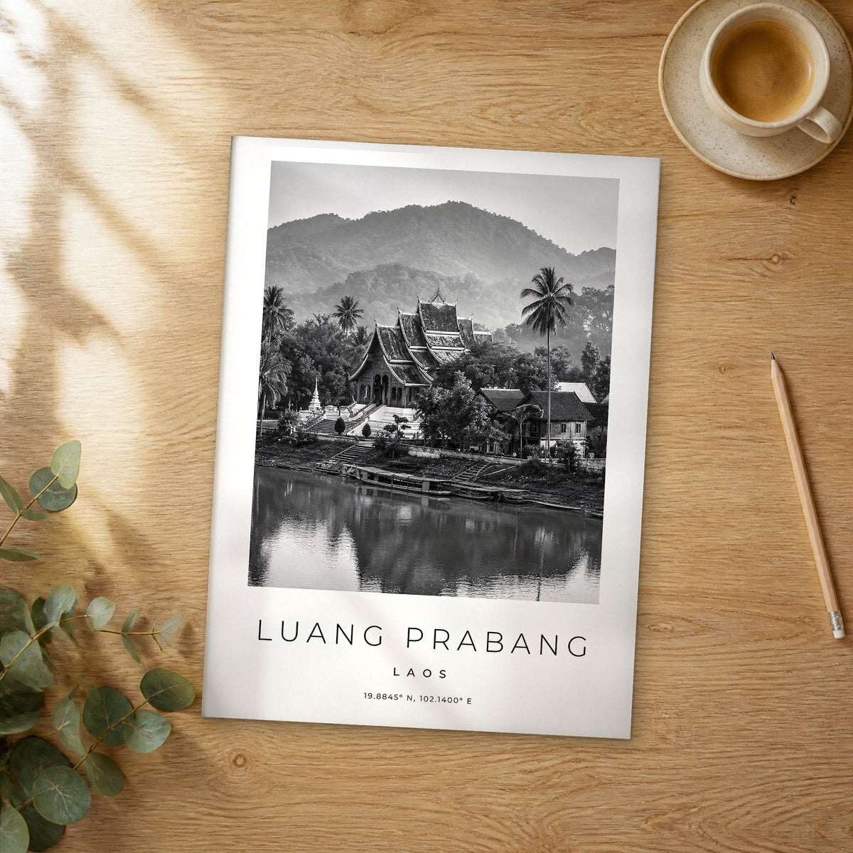 Unframed Luang Prabang black and white travel poster on a wooden table