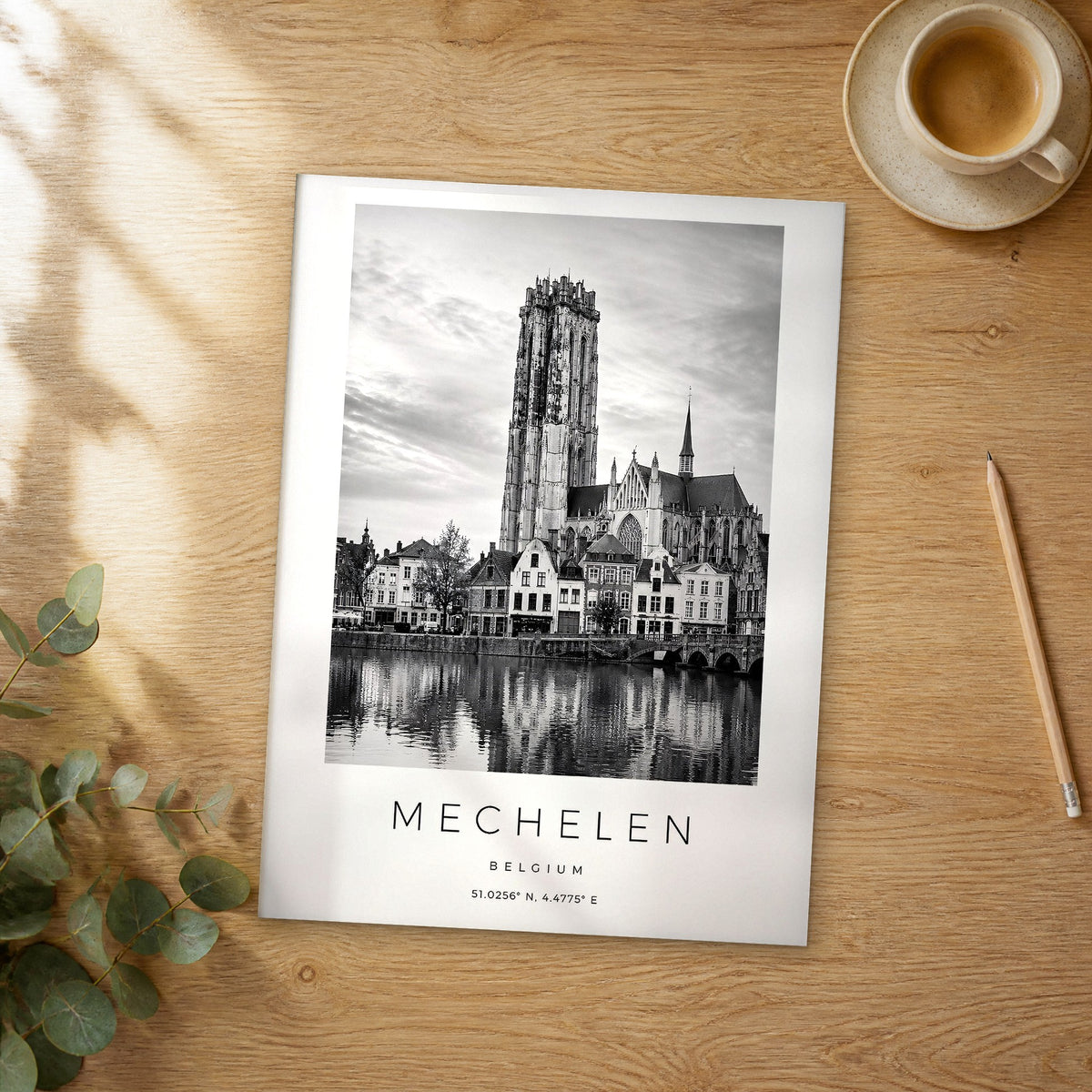 Unframed Mechelen black and white travel poster on a wooden table