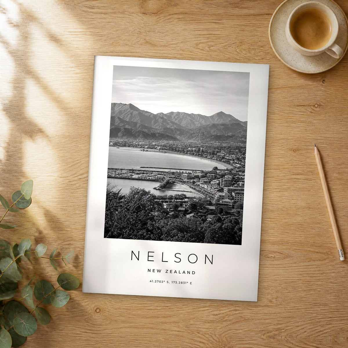 Unframed Nelson black and white travel poster on a wooden table