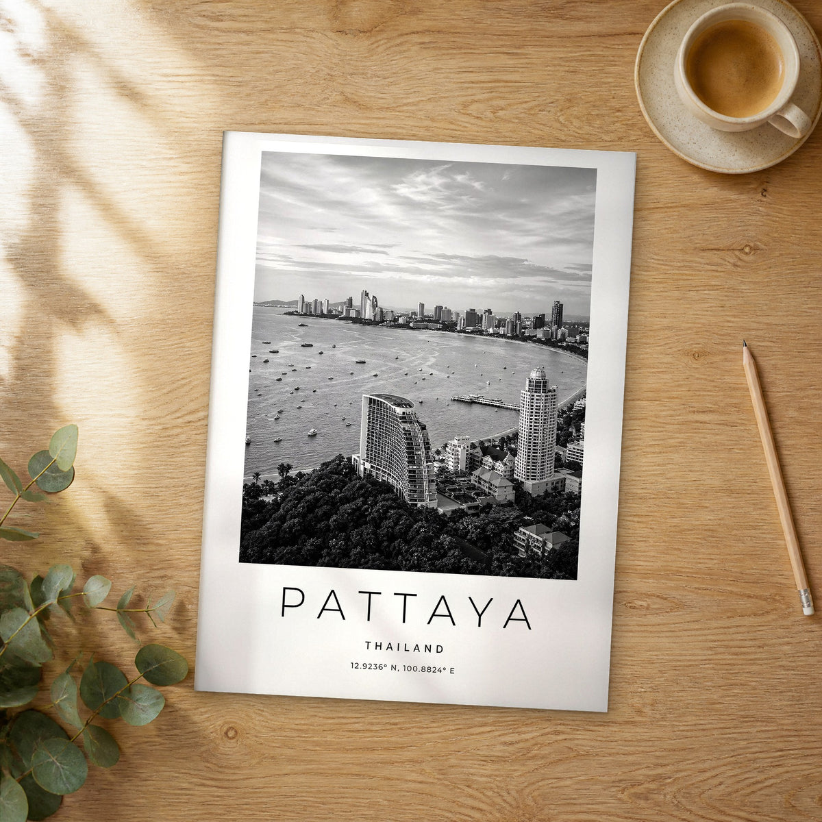 Unframed Pattaya black and white travel poster on a wooden table