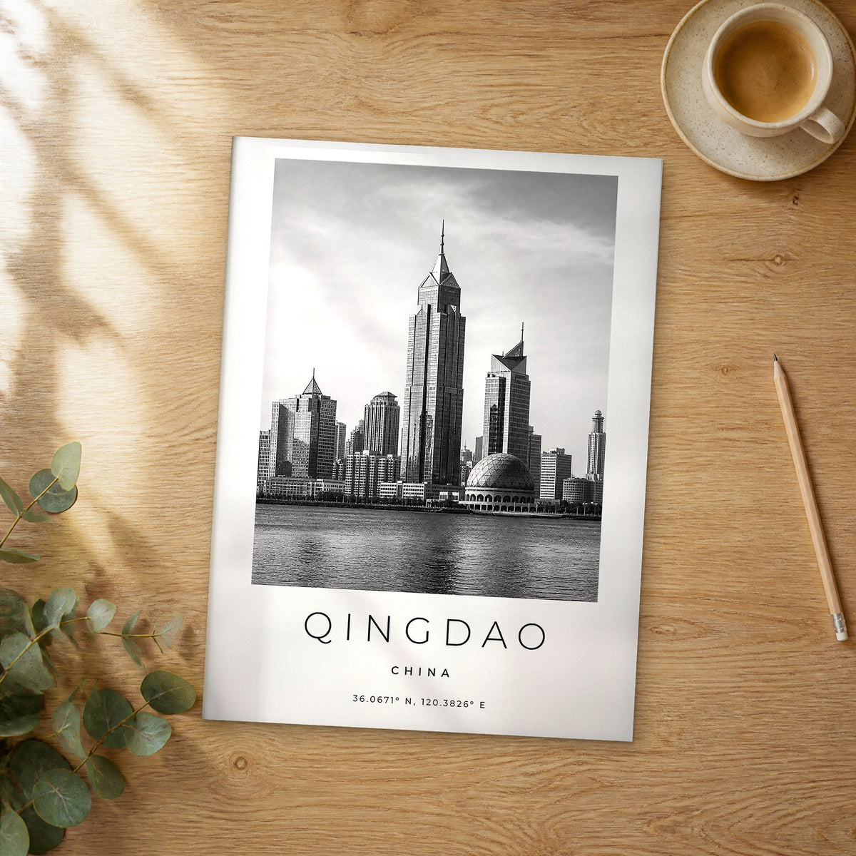 Unframed Qingdao black and white travel poster on a wooden table