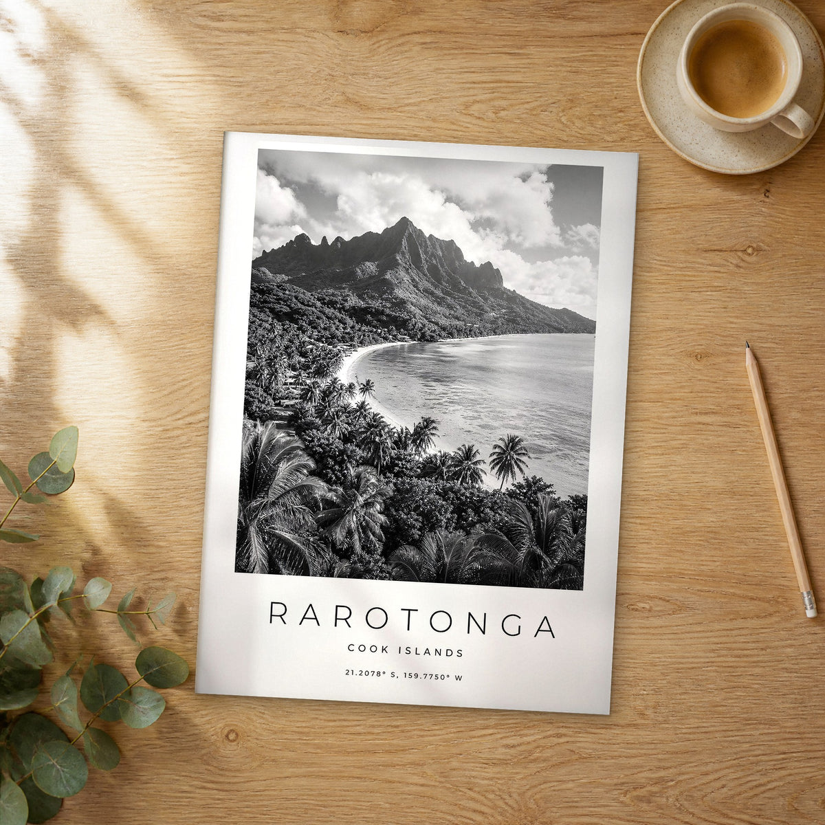 Unframed Rarotonga black and white travel poster on a wooden table