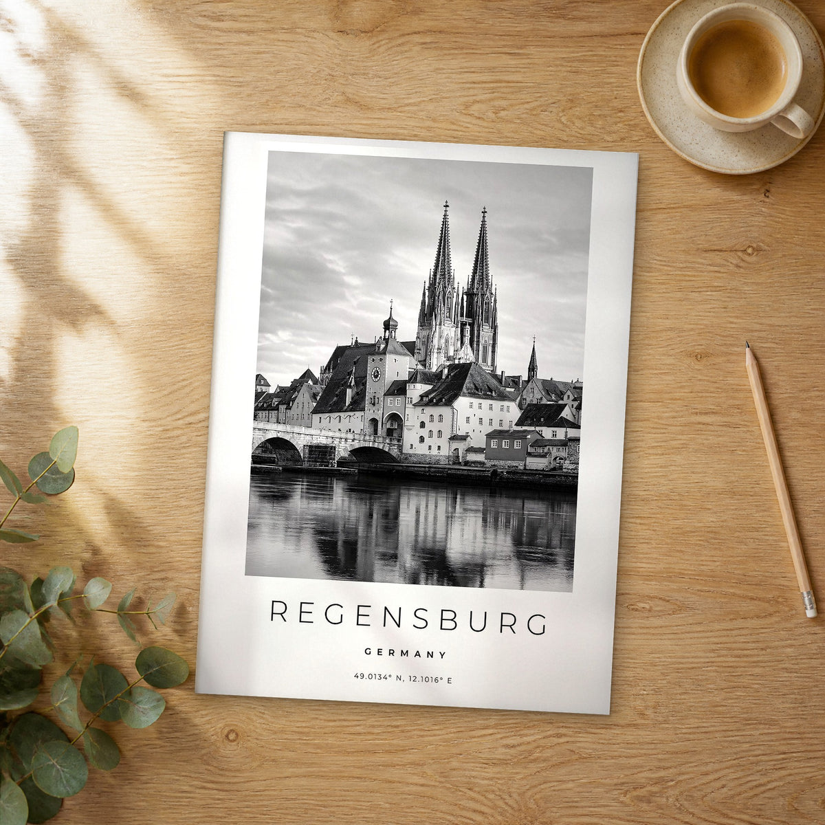 Unframed Regensburg black and white travel poster on a wooden table