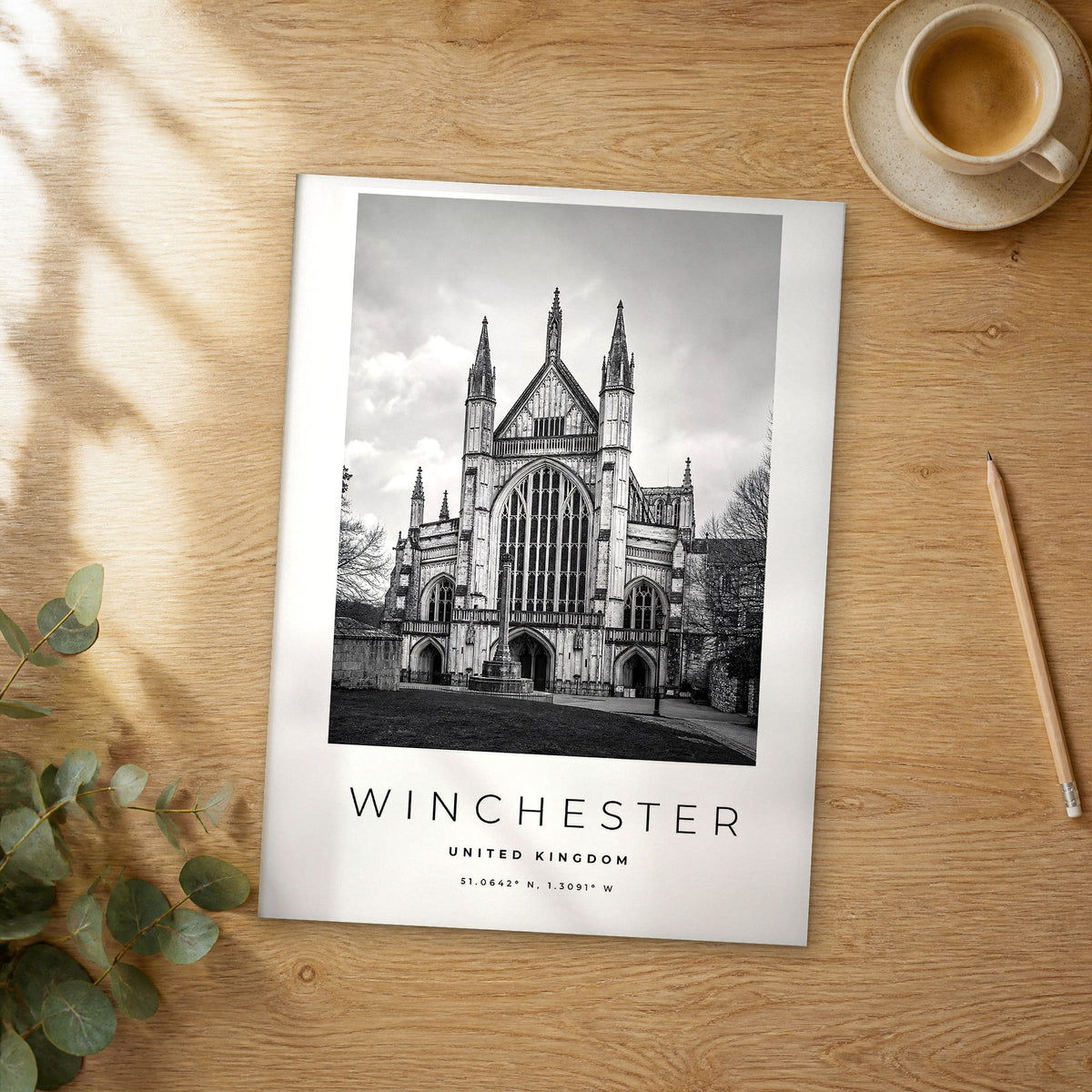 Unframed Winchester black and white travel poster on a wooden table