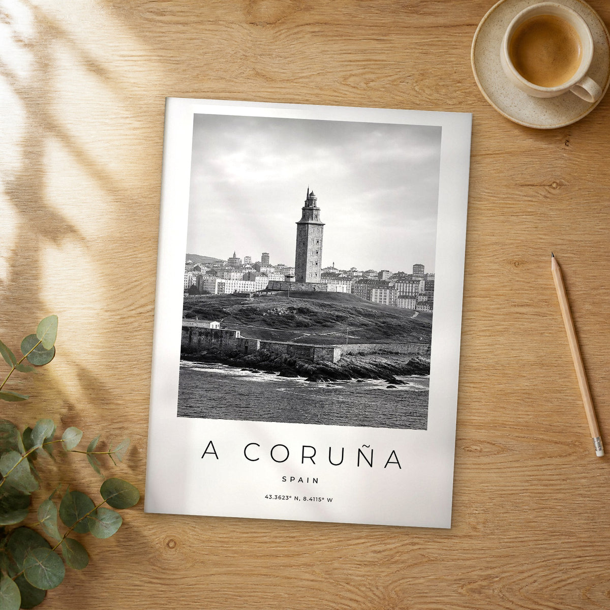 Unframed A Coruña black and white travel poster on a wooden table