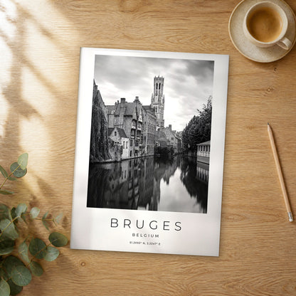 Unframed Bruges Belfry Canal Reflection black and white travel poster on a wooden table