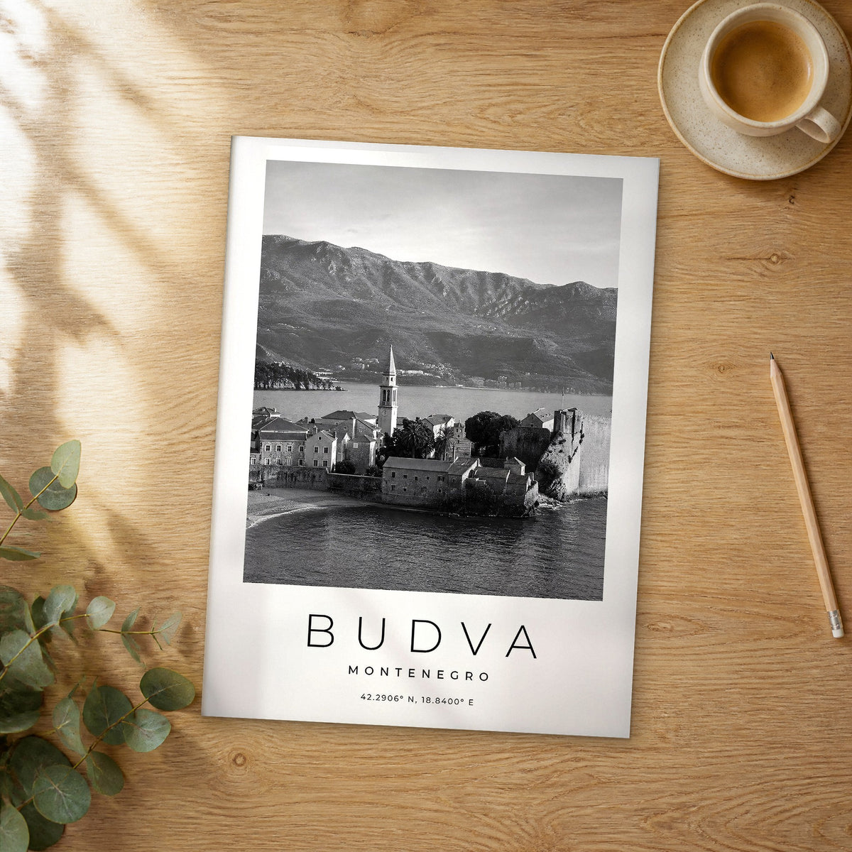 Unframed Budva black and white travel poster on a wooden table