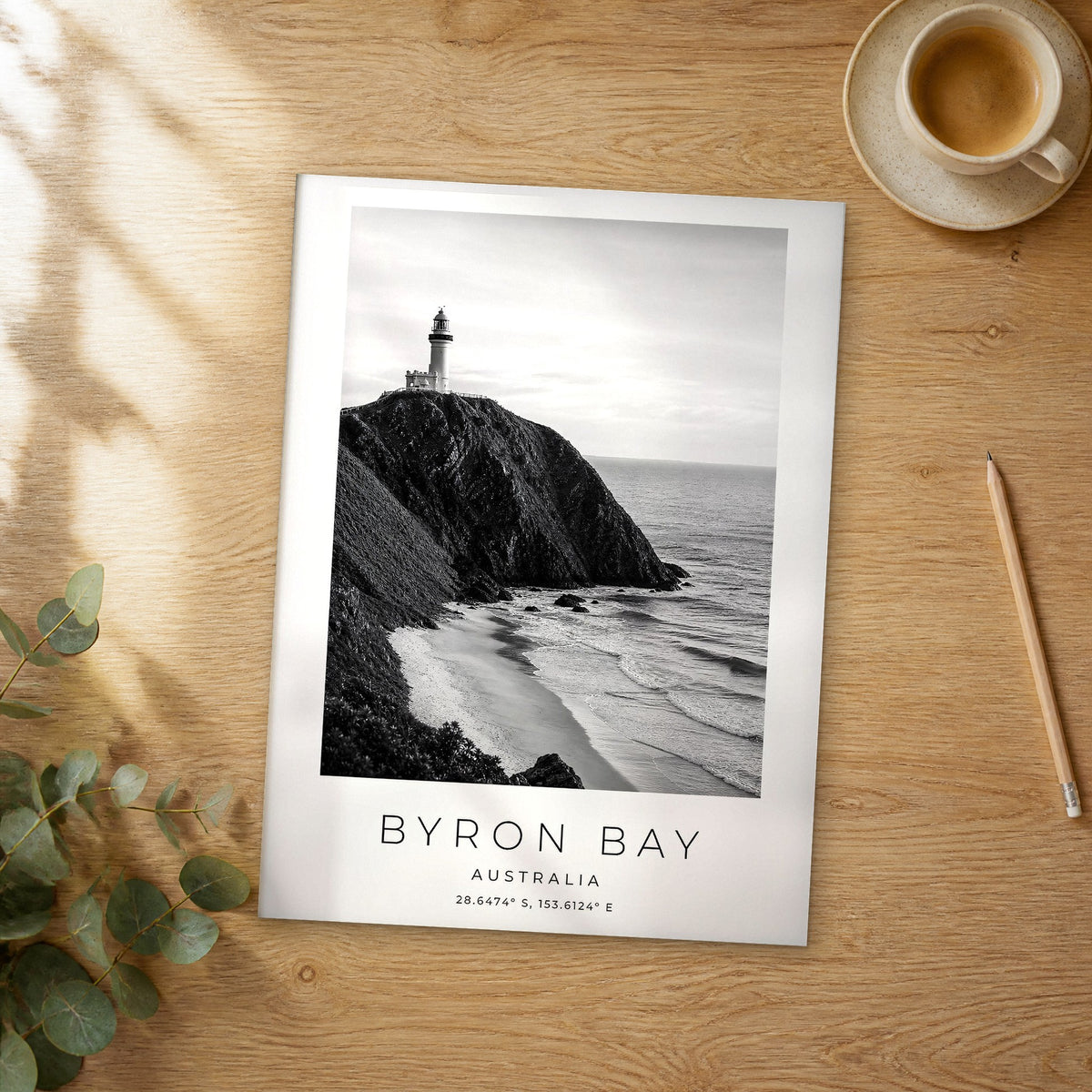 Unframed Byron Bay black and white travel poster on a wooden table