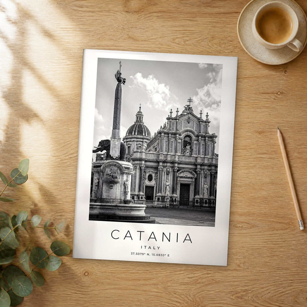 Unframed Catania black and white travel poster on a wooden table