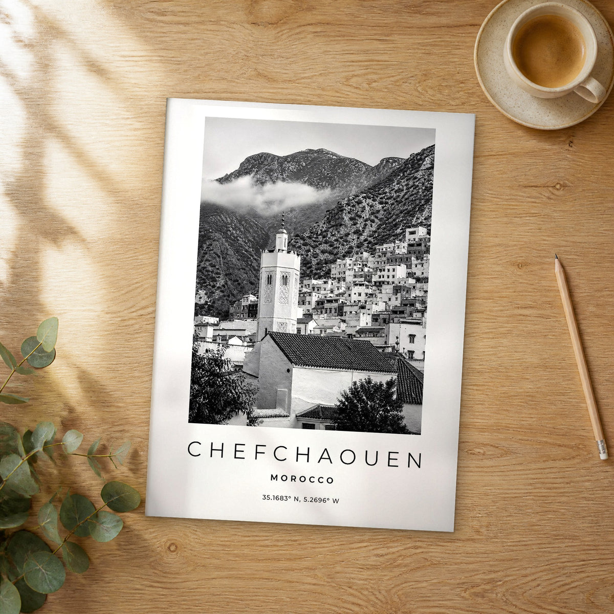 Unframed Chefchaouen black and white travel poster on a wooden table
