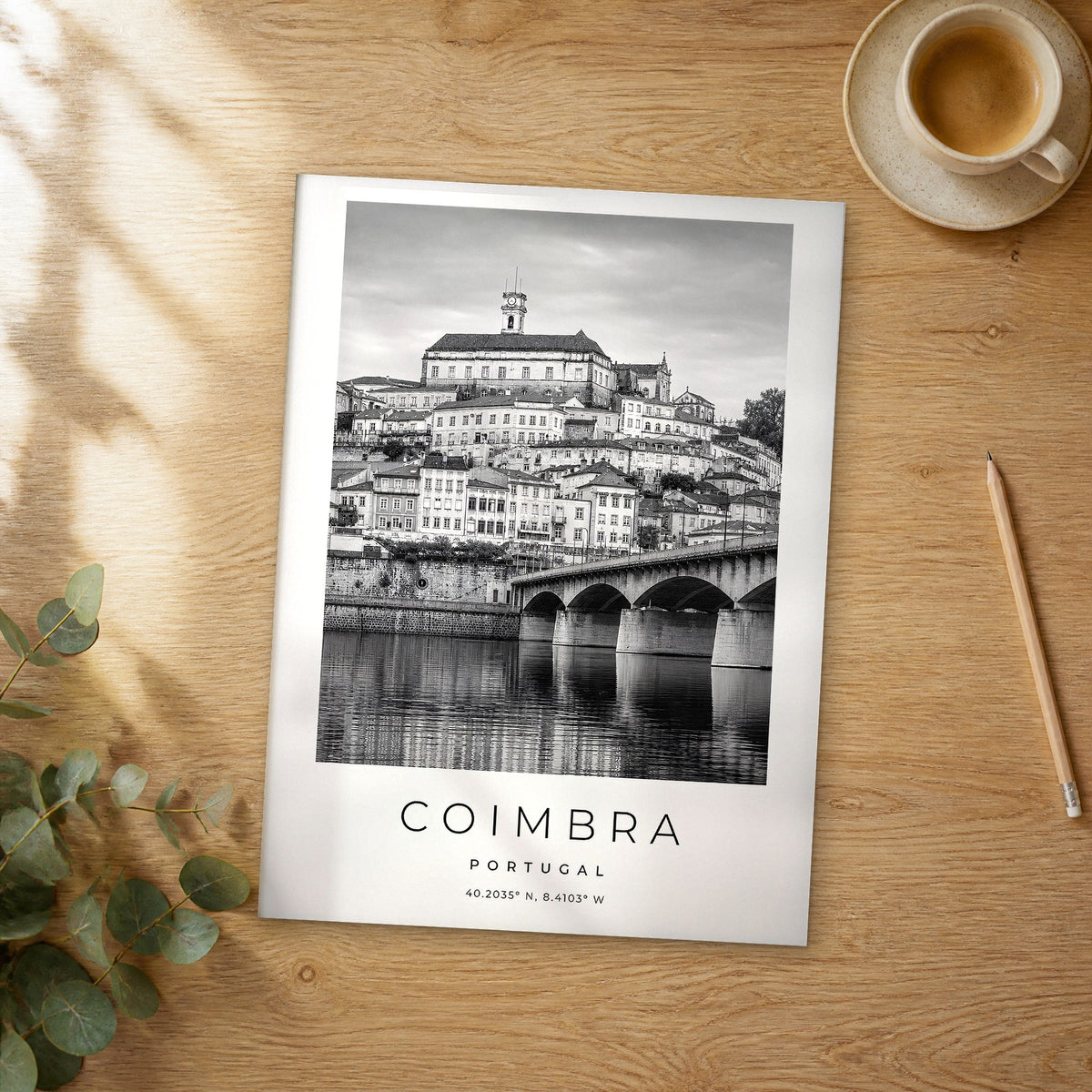 Unframed Coimbra black and white travel poster on a wooden table