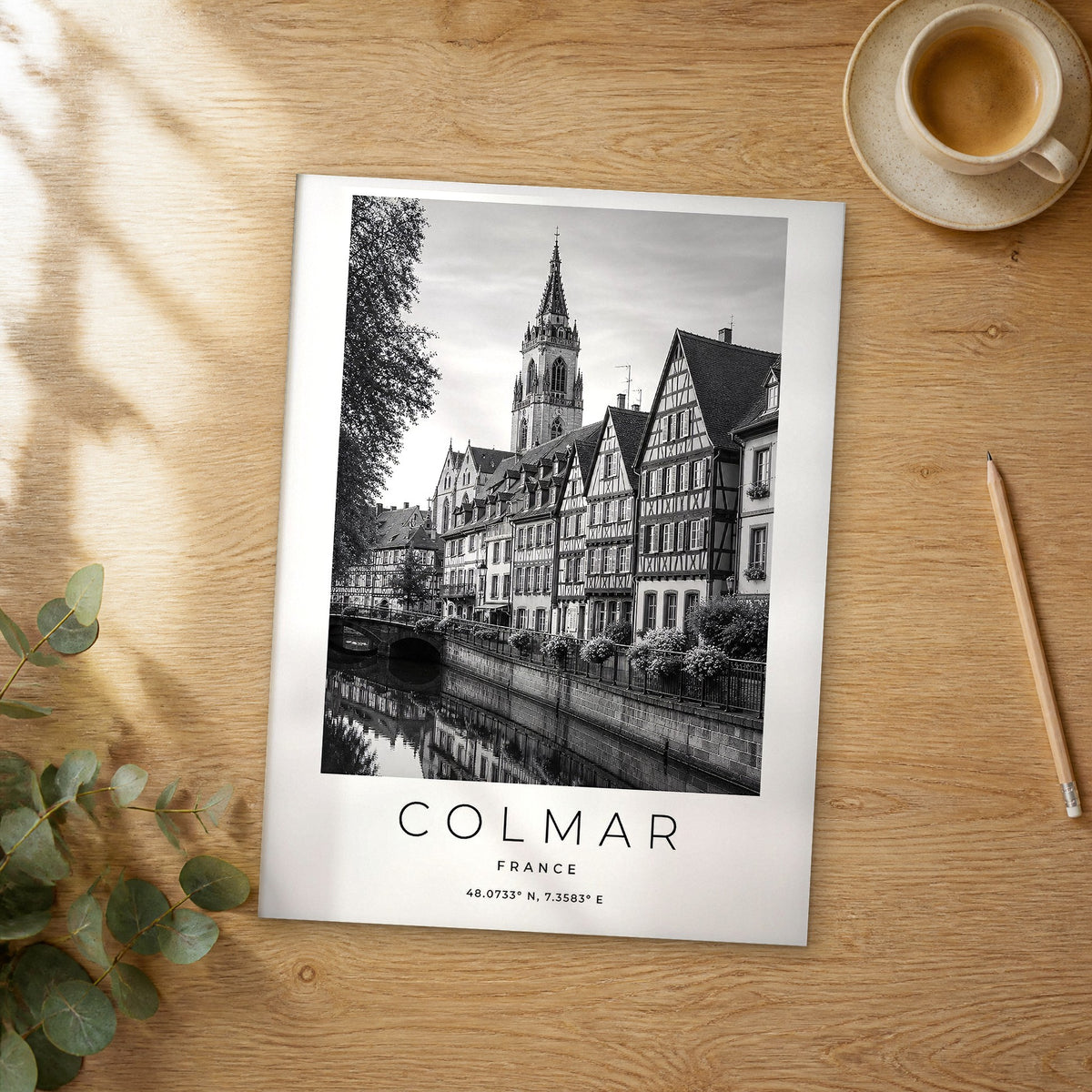 Unframed Colmar black and white travel poster on a wooden table