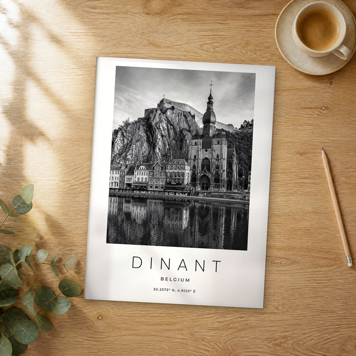 Unframed Dinant black and white travel poster on a wooden table