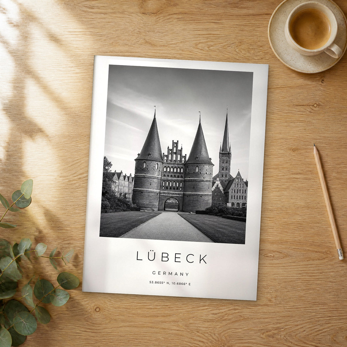 Unframed Lübeck black and white travel poster on a wooden table