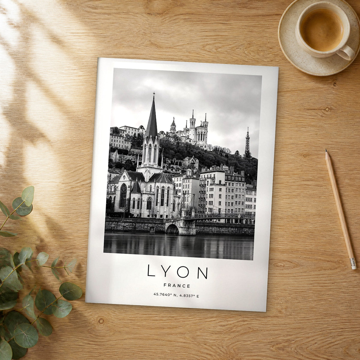 Unframed Lyon black and white travel poster on a wooden table