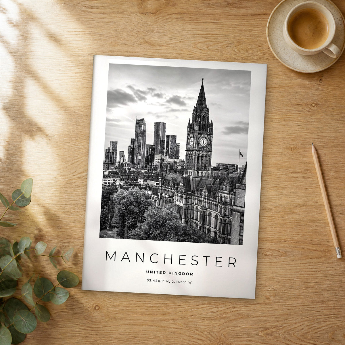 Unframed Manchester black and white travel poster on a wooden table