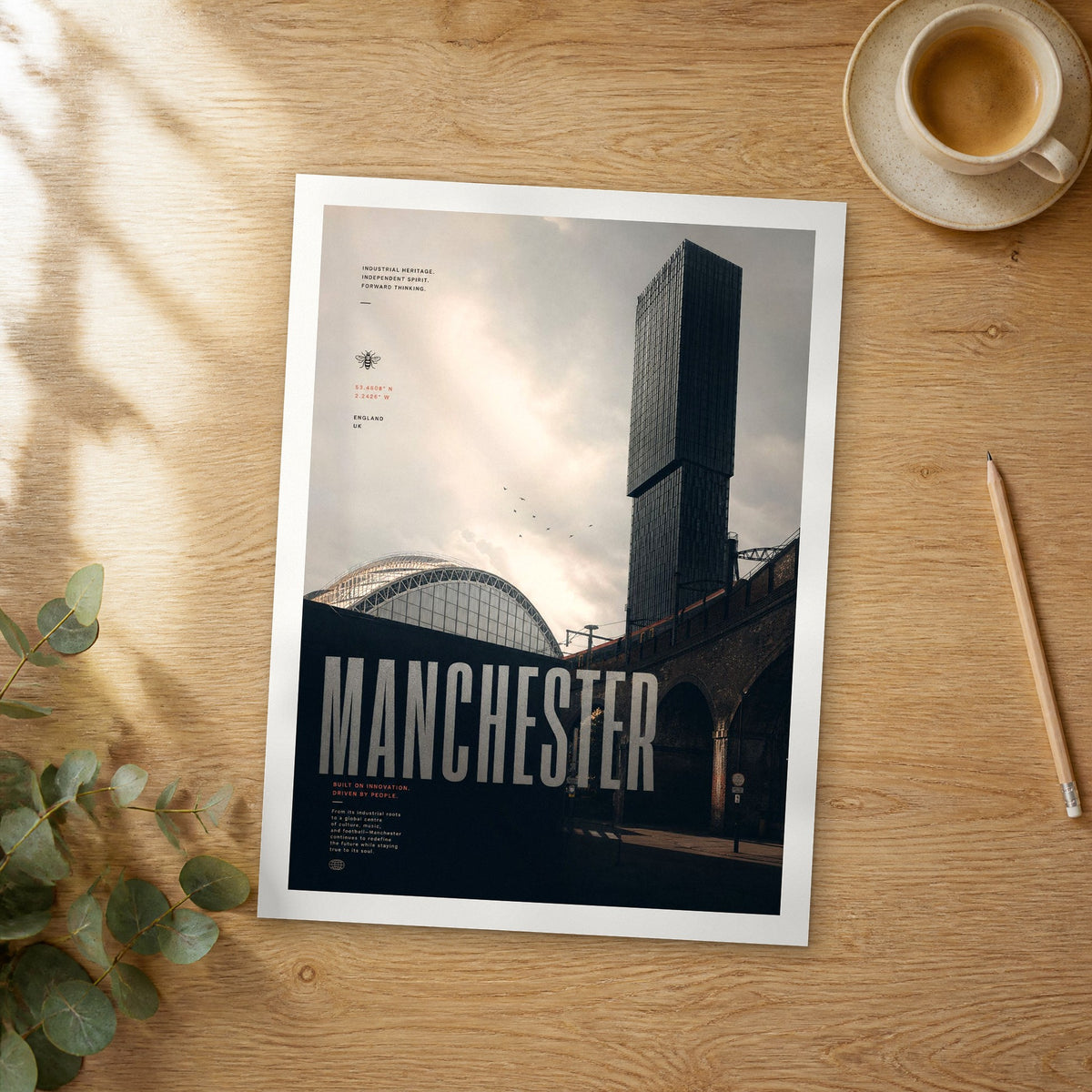 Unframed Manchester bold typography travel poster on a wooden table