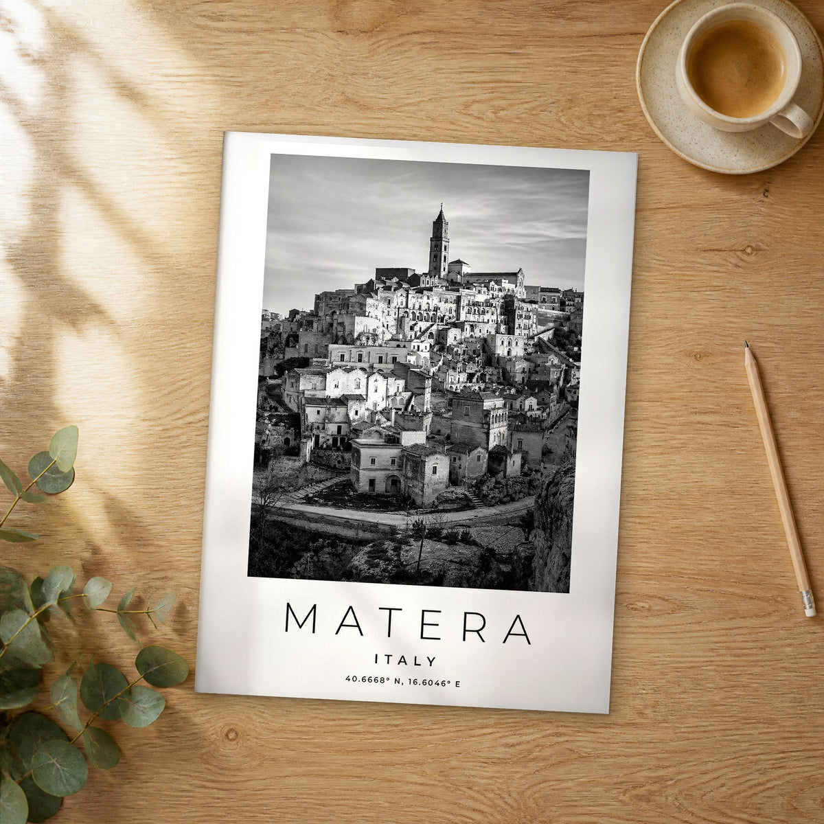 Unframed Matera black and white travel poster on a wooden table