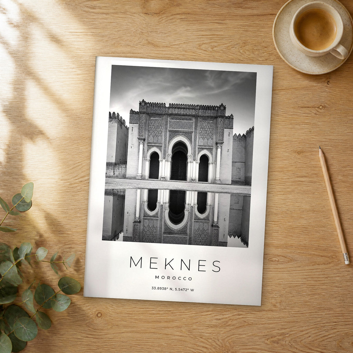 Unframed Meknes black and white travel poster on a wooden table