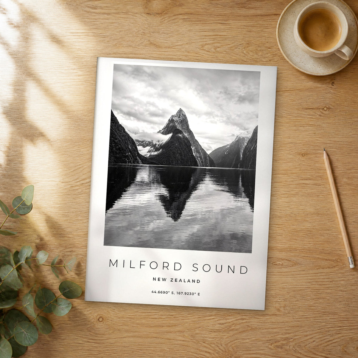 Unframed Milford Sound black and white travel poster on a wooden table