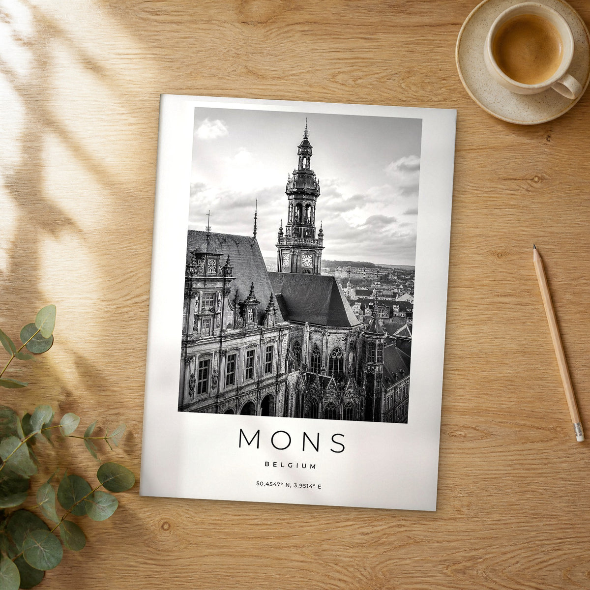 Unframed Mons black and white travel poster on a wooden table