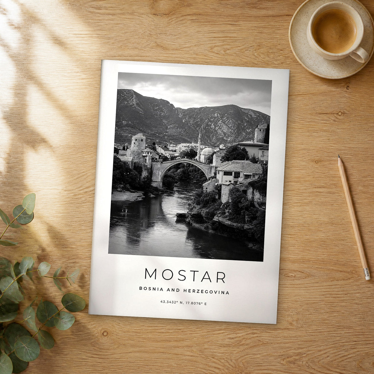 Unframed Mostar black and white travel poster on a wooden table