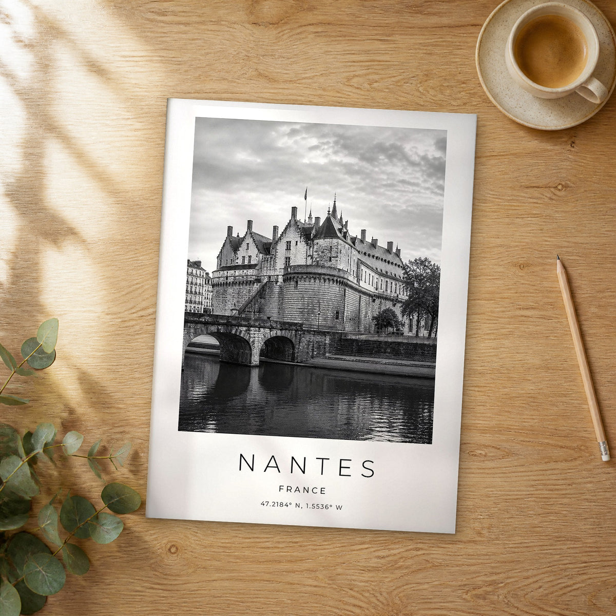 Unframed Nantes black and white travel poster on a wooden table