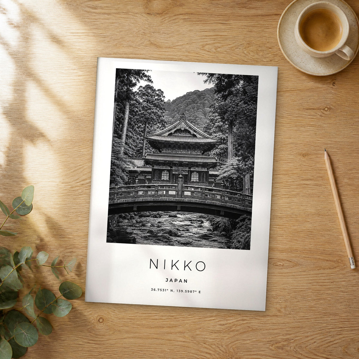 Unframed Nikko black and white travel poster on a wooden table