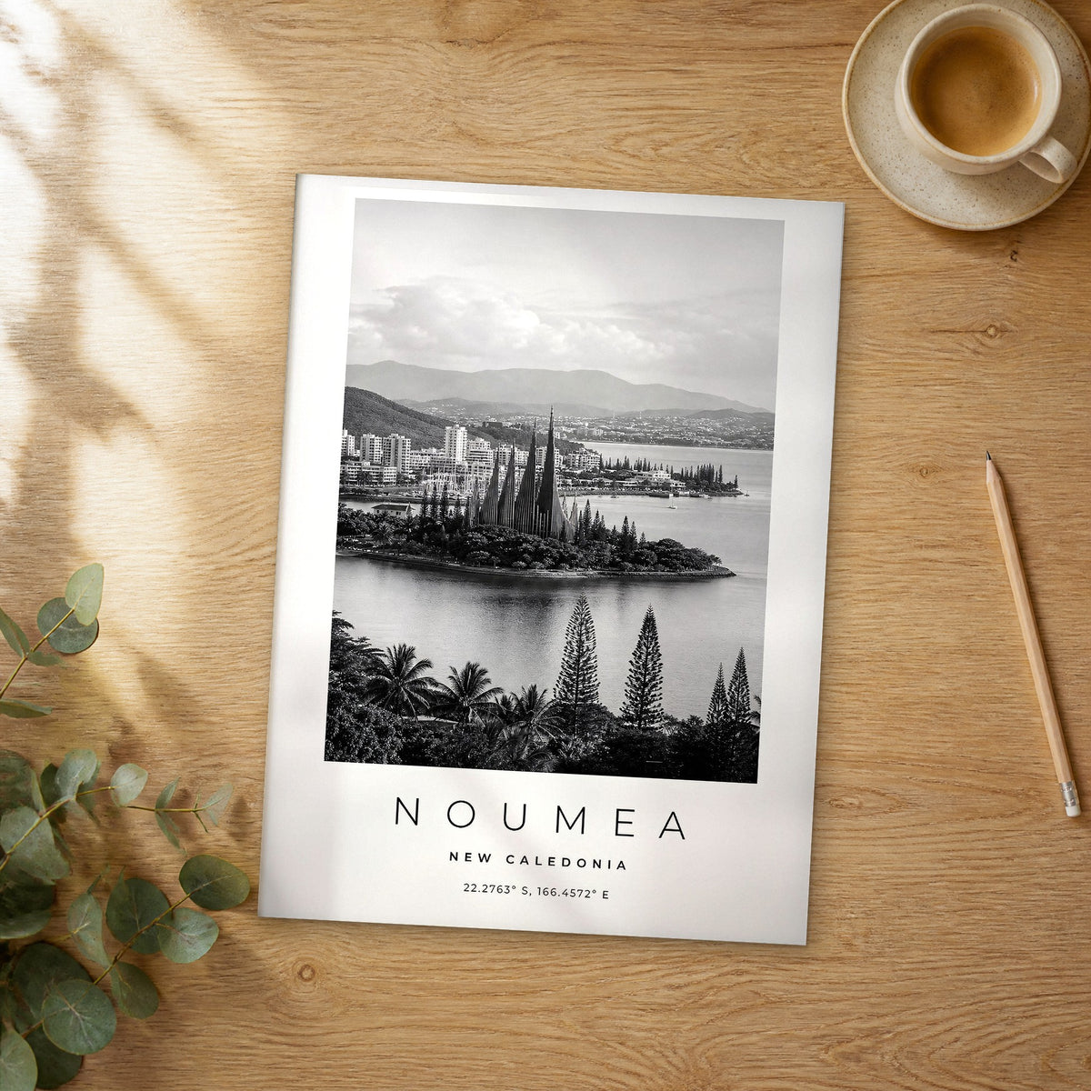 Unframed Noumea black and white travel poster on a wooden table