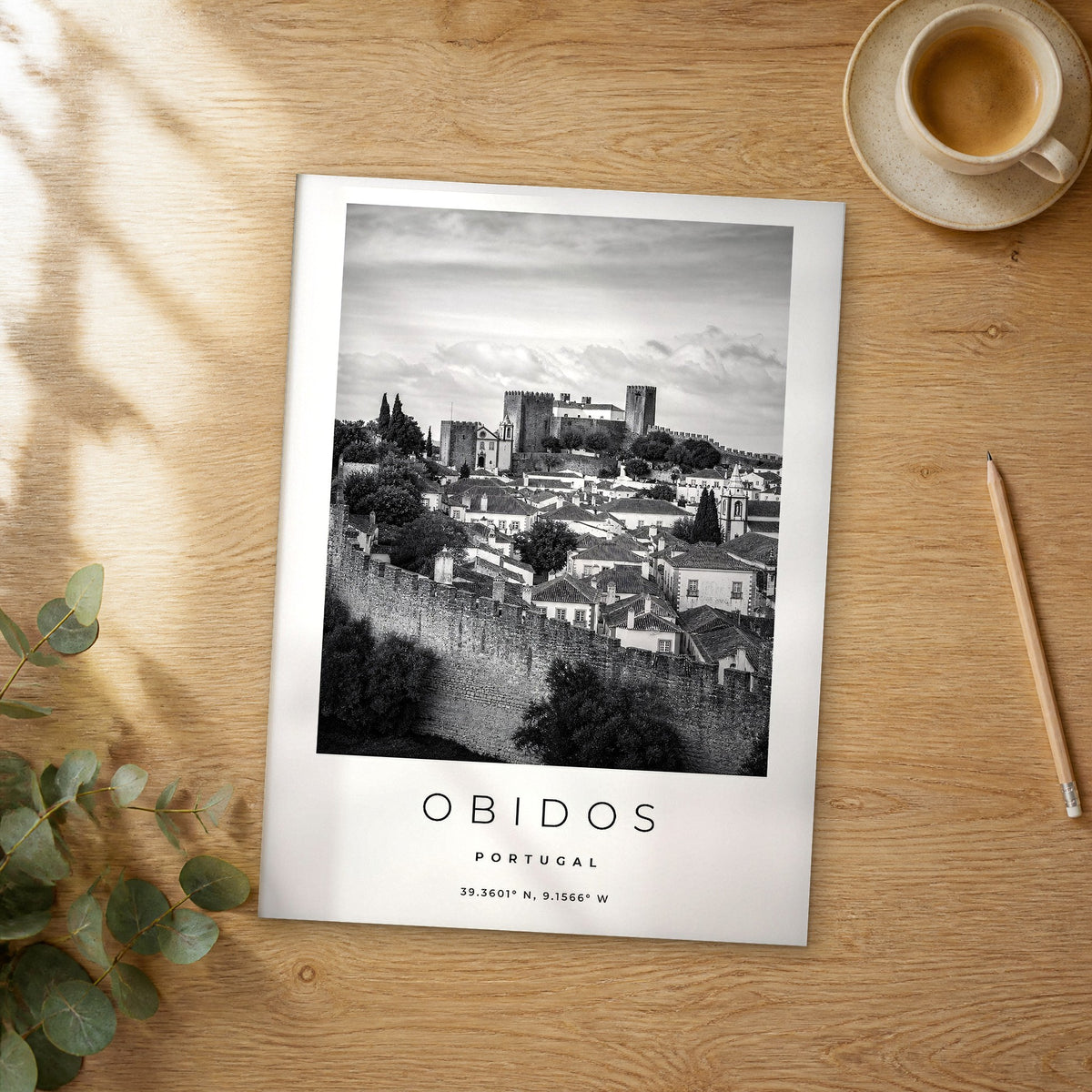 Unframed Obidos black and white travel poster on a wooden table