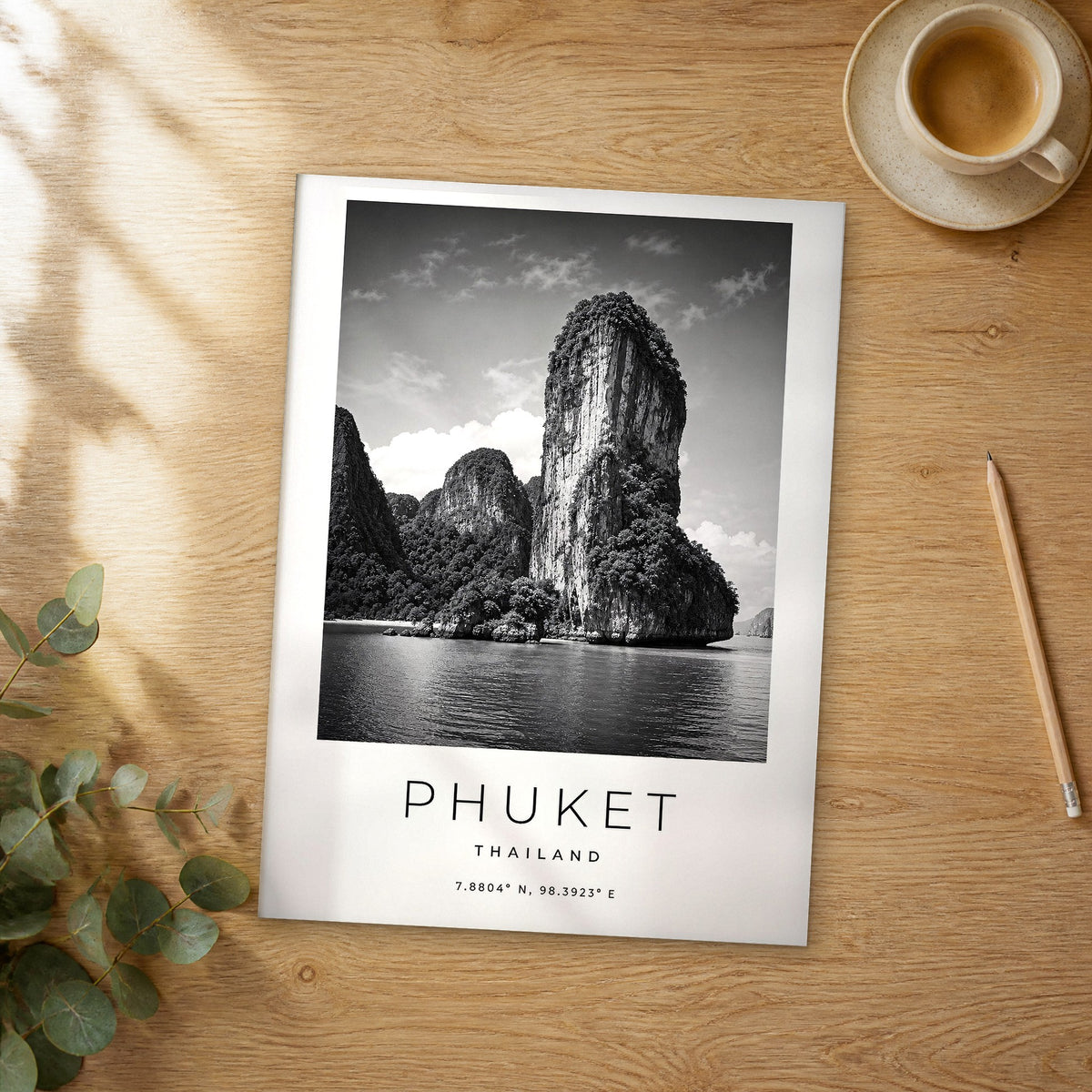 Unframed Phuket black and white travel poster on a wooden table