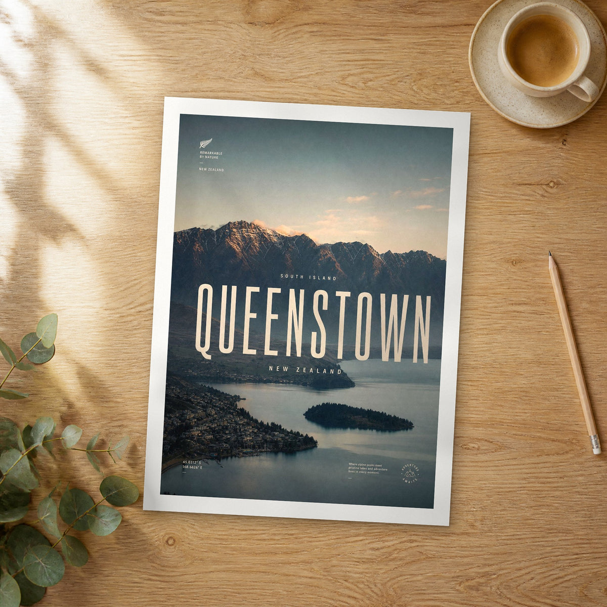 Unframed Queenstown bold typography travel poster on a wooden table