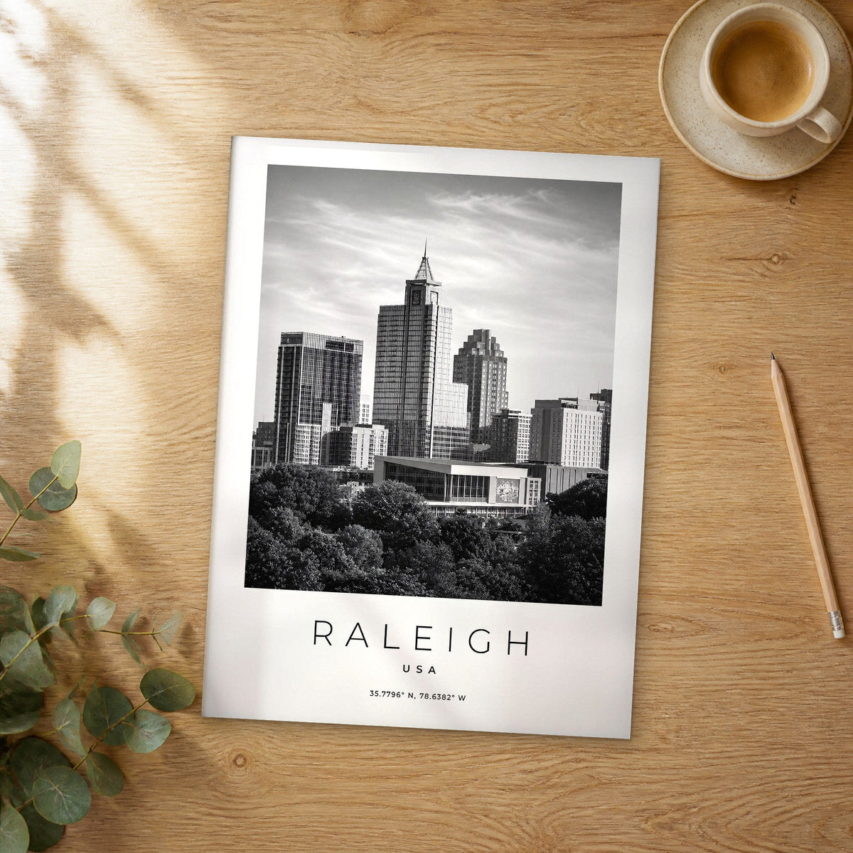 Unframed Raleigh black and white travel poster on a wooden table