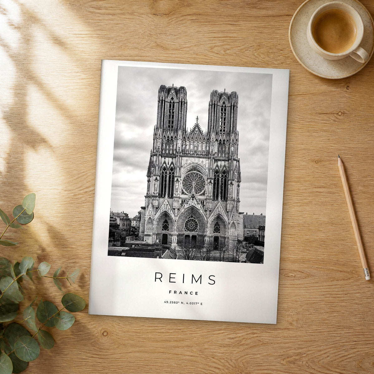 Unframed Reims black and white travel poster on a wooden table