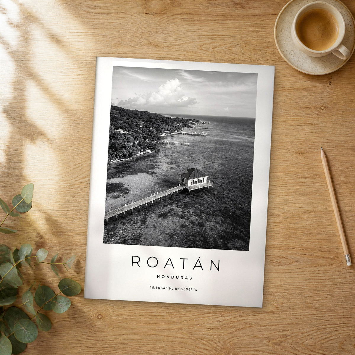 Unframed Roatán black and white travel poster on a wooden table