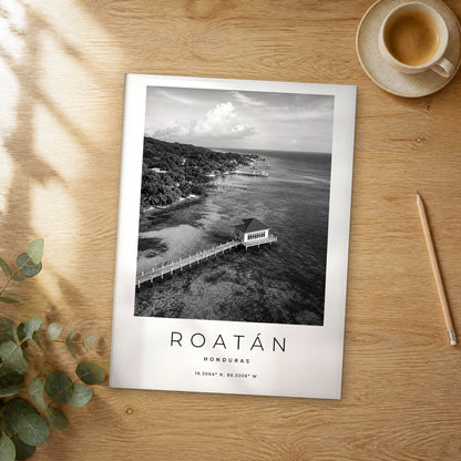 Unframed Roatán black and white travel poster on a wooden table