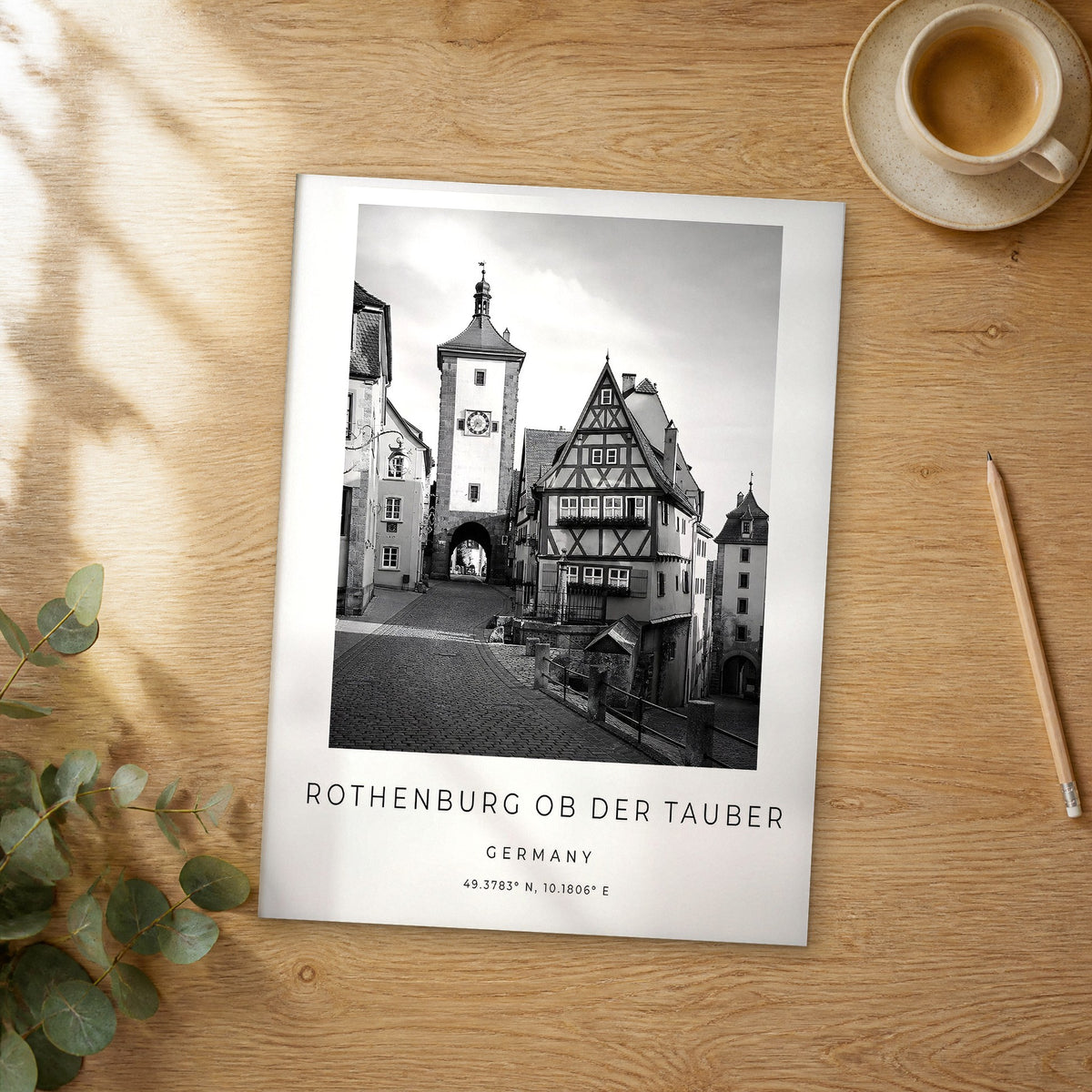 Unframed Rothenburg ob der Tauber black and white travel poster on a wooden table