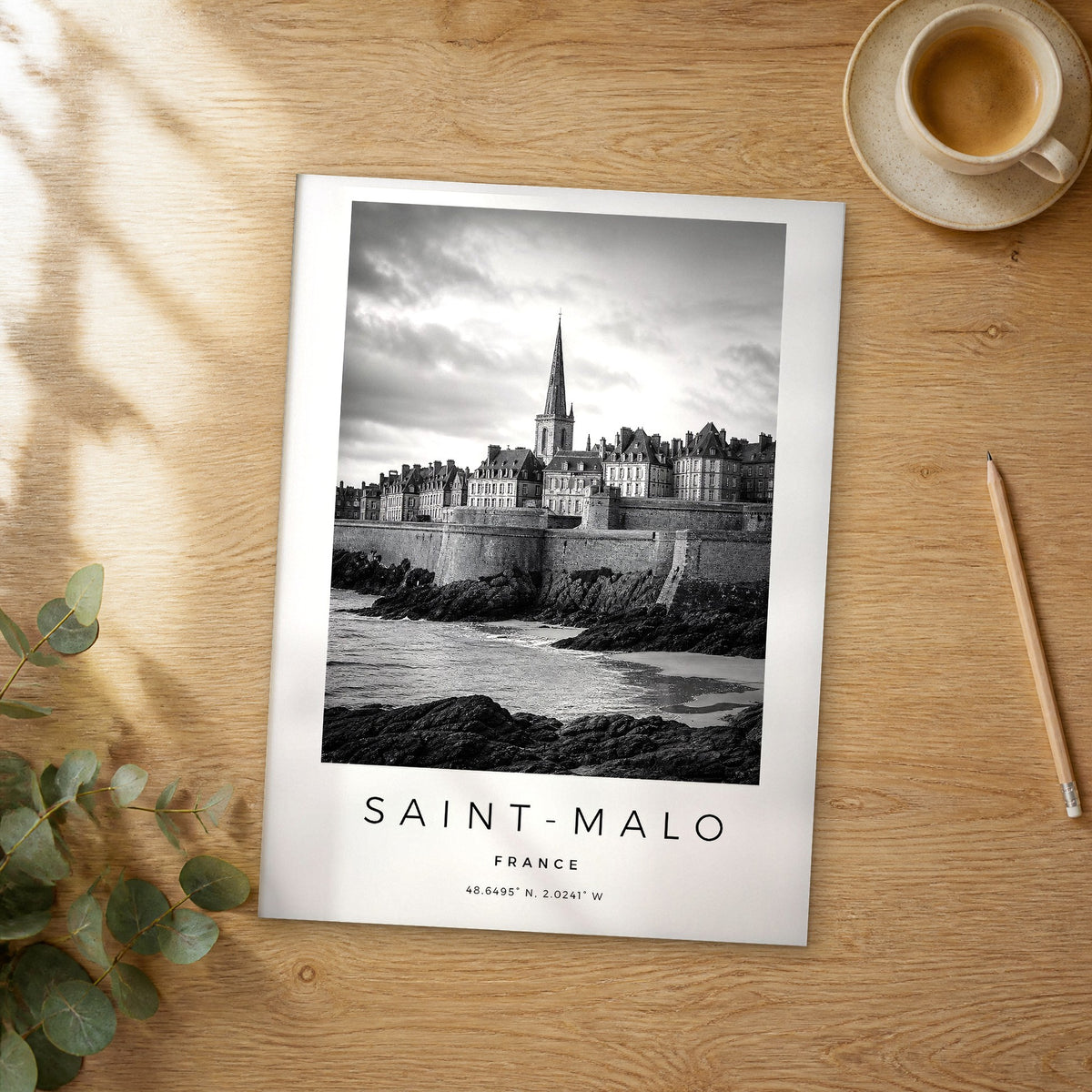 Unframed Saint-Malo black and white travel poster on a wooden table