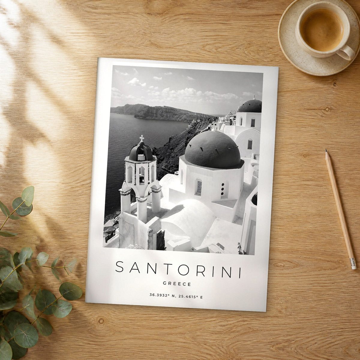 Unframed Santorini black and white travel poster on a wooden table