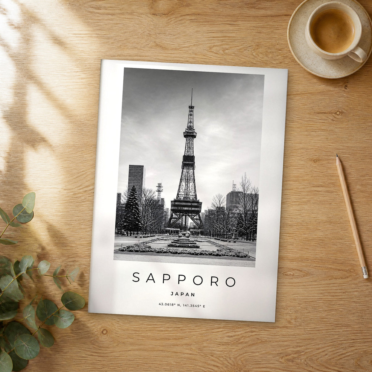 Unframed Sapporo black and white travel poster on a wooden table